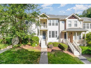 Well-maintained townhome with manicured lawn, charming entryway, and second story balcony at 521 Village Loop Dr, Apex, NC 27502