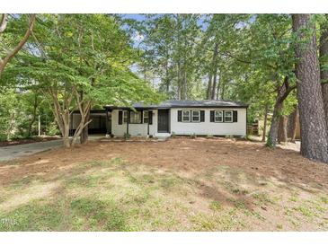 Charming single-story home featuring classic curb appeal with black accents and mature trees in the front yard at 620 Wexford Dr, Raleigh, NC 27603
