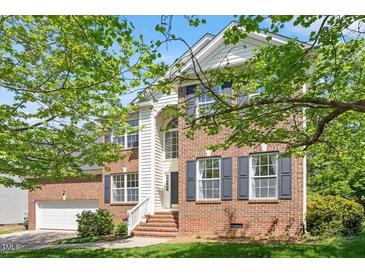 Charming two-story brick home with an attached garage, landscaped yard, and classic architectural details at 1007 Grandover Dr, Durham, NC 27713