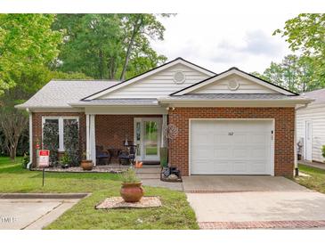 Charming single story brick home with manicured lawn and attached one car garage at 102 Fairgrove Way Way, Cary, NC 27511