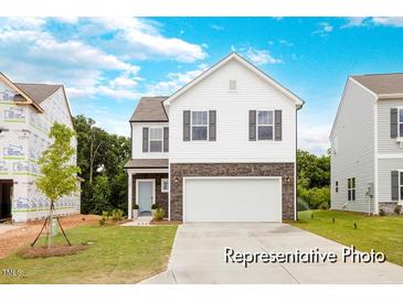 Charming two-story home featuring stone accents, white siding, and a spacious two-car garage at 104 S Buggy Dr # 71P, Benson, NC 27504