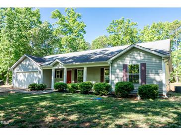 Charming single-story home featuring a well-manicured lawn and an attached garage at 116 Shawnee Dr, Louisburg, NC 27549