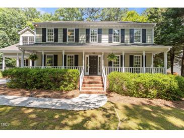 Charming traditional home with a welcoming front porch, manicured landscaping, and classic shutters at 128 Cobblestone Dr, Chapel Hill, NC 27516