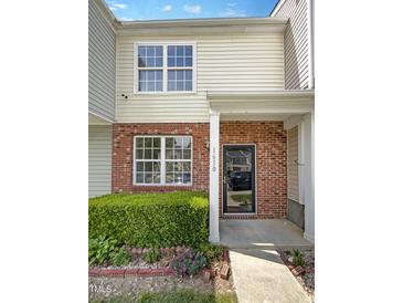 Inviting townhome entrance with brick facade, well-kept landscaping, and a bright, welcoming exterior at 1610 Oxleymare Dr, Raleigh, NC 27610