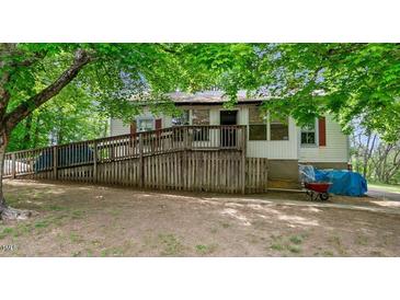 Charming single-story home featuring a ramp for accessibility and surrounded by lush greenery and mature trees at 1701 Sunset St, Roxboro, NC 27573