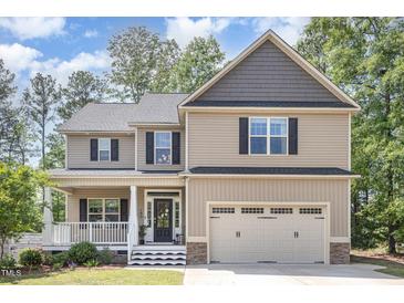 Charming two-story home featuring a covered front porch and attached two car garage at 180 Long Grass Dr, Smithfield, NC 27577