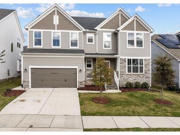 Charming two-story home featuring a mix of siding and stone accents, a two-car garage, and a well-manicured front yard at 1816 Sandoval Dr, Durham, NC 27703