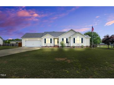 Charming single-story home featuring a well-manicured lawn, an attached garage and an American flag at 182 Jesse Dr, Smithfield, NC 27577