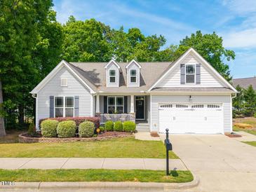 Charming one-story home featuring a landscaped yard and a two-car garage at 275 N Farm Dr, Clayton, NC 27527