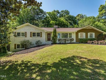 Charming single-story home with brick and siding, front yard with mature trees and manicured landscaping at 3009 Hillmer Dr, Raleigh, NC 27609