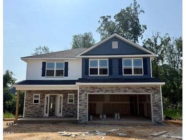 New construction with stone accents, blue shutters and siding under a clear, sunny sky at 327 Bishop Ln, Sanford, NC 27330