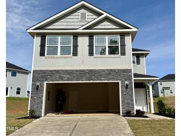 Two-story home with gray siding, black shutters, and stone accents over the garage at 332 Bishop Ln, Sanford, NC 27330