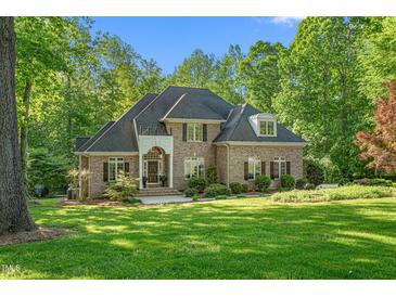 Stately brick home with manicured lawn, mature trees, and welcoming front entrance at 3440 Black Bear Cv, Burlington, NC 27215