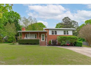 Charming brick two-story home with manicured lawn and mature trees in a quiet neighborhood at 5144 Jeffries St, Raleigh, NC 27606