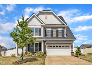 Inviting two-story home featuring a two-car garage, well-manicured lawn, and beautiful landscaping at 5525 Garnet Meadow Rd, Knightdale, NC 27545