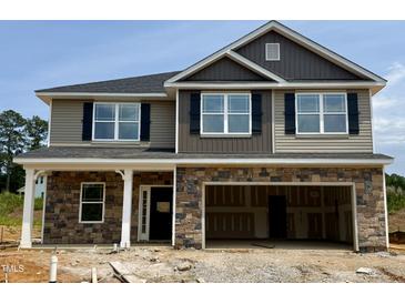 Two-story home featuring a stone facade, hardiplank siding, black shutters, and a two-car garage at 606 Melrose Ct, Sanford, NC 27330