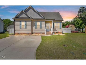 Charming single-story home boasts a manicured lawn, a concrete driveway, and classic curb appeal at 608 W Godwin St, Dunn, NC 28334
