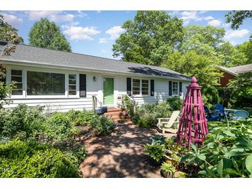Charming one story home with a brick walkway and beautifully landscaped front yard at 708 W Main St, Carrboro, NC 27510