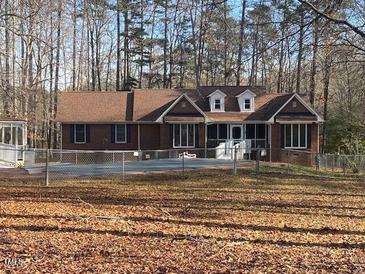 Charming single-story brick home with a well-maintained lawn and surrounding woods at 80 White Deer Ln, Henderson, NC 27537