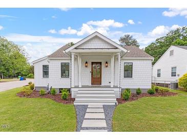 Charming white home with a welcoming front porch and landscaped yard at 1112 Watauga Street St, Raleigh, NC 27604