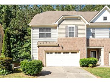 Charming brick and siding townhome with an attached garage and manicured landscaping at 1175 Contessa Dr, Cary, NC 27513