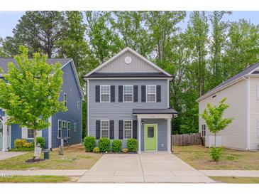 Charming two-story home with a well-manicured lawn, a bright green door, and a concrete driveway at 138 Yellow Jacket Rdg, Clayton, NC 27520