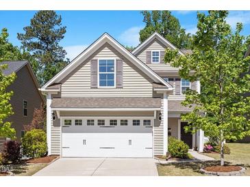 Charming two-story home featuring a two-car garage, gray siding and a well-manicured lawn at 214 Dogwood Blossoms Dr, Durham, NC 27703