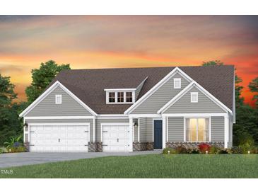 Charming single-story home showcasing a three-car garage, gray siding and a manicured front lawn at 2412 Del Webb Gardens Dr, Fuquay Varina, NC 27526