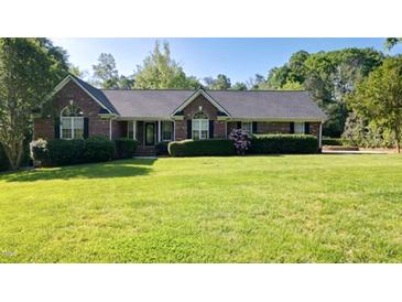 Charming brick home featuring manicured landscaping and a sprawling green lawn at 2457 Millbrook Dr, Haw River, NC 27258