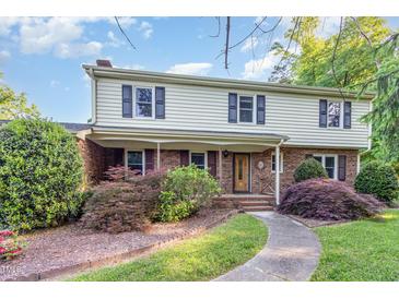 Charming two-story home featuring a brick facade, covered porch, and beautifully landscaped front yard at 3209 Marie Dr, Raleigh, NC 27604