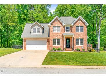 Charming two-story brick home featuring a well-manicured lawn and a two-car garage at 3436 Candlebrook Ct, Mebane, NC 27302