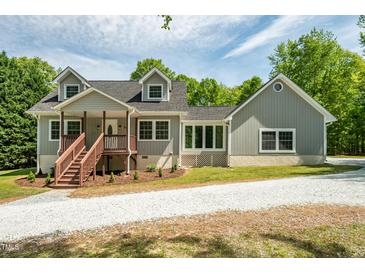 Charming gray home featuring a covered porch and well-maintained landscaping at 35 Fire Tower Dr, Rougemont, NC 27572