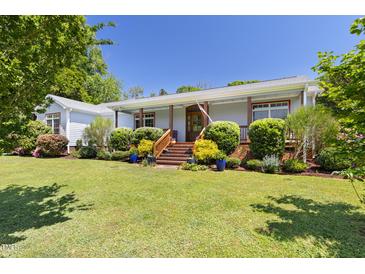 Charming single-story home featuring a beautifully landscaped front yard and welcoming front porch at 416 Mitchell St, Hillsborough, NC 27278