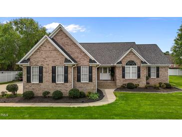 Charming brick home featuring a well-manicured lawn, black shutters, and a classic entryway at 4589 Freedom Dr, Burlington, NC 27215