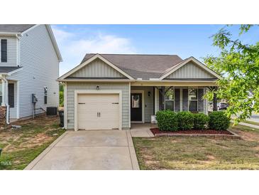 Charming single-story home with a well-manicured lawn and inviting covered front porch at 51 Balboa Parkway Pkwy, Clayton, NC 27520