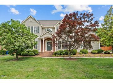 Charming two-story home with a manicured lawn, mature trees, and a welcoming brick entrance at 608 Driftwood Dr, Gibsonville, NC 27249