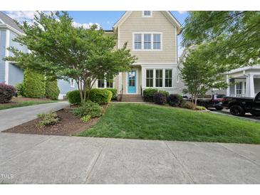 Charming two-story home featuring a well-manicured lawn and a vibrant turquoise front door at 707 Sasser St, Raleigh, NC 27604
