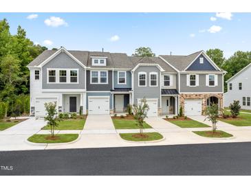 Charming townhome exteriors featuring varied colors and attached garages for convenient living in a vibrant community at 908 Kensley Grove Lane St #69, Fuquay Varina, NC 27526
