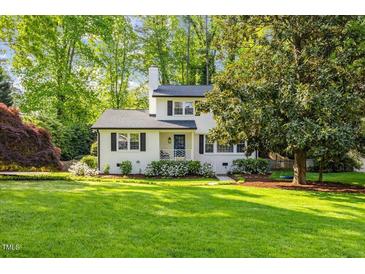 Charming two-story home with landscaped yard, blue door, black shutters, and a manicured lawn on a sunny day at 1008 Winona Rd, Raleigh, NC 27609