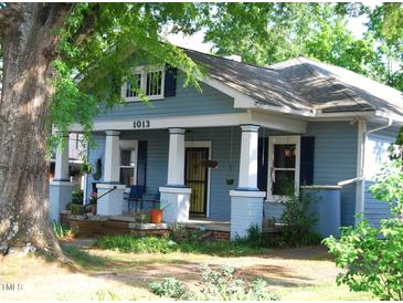Charming blue two-story home featuring a covered front porch with white columns and manicured landscaping at 1013 Green St, Durham, NC 27701