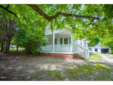 Charming home with a cozy front porch and mature trees providing shade at 1015 Cross Link Rd, Raleigh, NC 27610