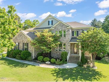 Stunning two-story brick home with a well-manicured lawn and beautiful landscaping at 1046 Covered Bridge Trl, Chapel Hill, NC 27517