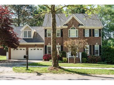 Charming brick two-story home with a two-car garage, black shutters, and well-maintained landscaping at 105 Kenmont Dr, Holly Springs, NC 27540