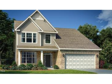 Charming two-story home featuring stone accents, a two-car garage, and a well-manicured lawn at 1105 Owen Park Dr, Gibsonville, NC 27249