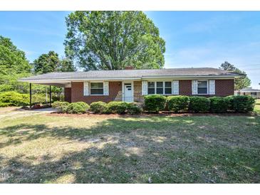 Charming single-story brick home featuring manicured hedges, white shutters and covered parking at 11234 Nc Hwy 50, Benson, NC 27504