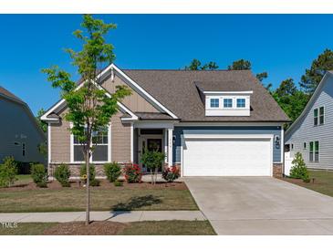 Charming home featuring a two-car garage, manicured lawn, and inviting curb appeal at 116 Alumroot Rd, Holly Springs, NC 27540