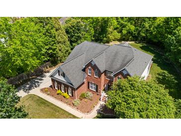 Aerial view of a two-story brick home with lush landscaping and a well-maintained roof at 1258 Jamestowne Dr, Elon, NC 27244