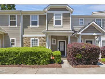 Inviting townhome with stone accents, manicured landscaping, and a cozy front porch at 2207 Bankshill Row, Raleigh, NC 27614