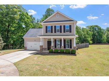 Charming two-story home featuring a well-manicured lawn, attached garage, and inviting front porch at 274 Tuscarora Ln, Clayton, NC 27520