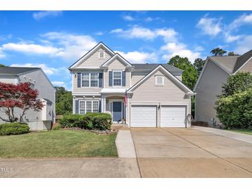 Charming two-story home features a two-car garage, blue shutters, and manicured lawn on a sunny day at 312 Grassy Point Rd, Apex, NC 27502
